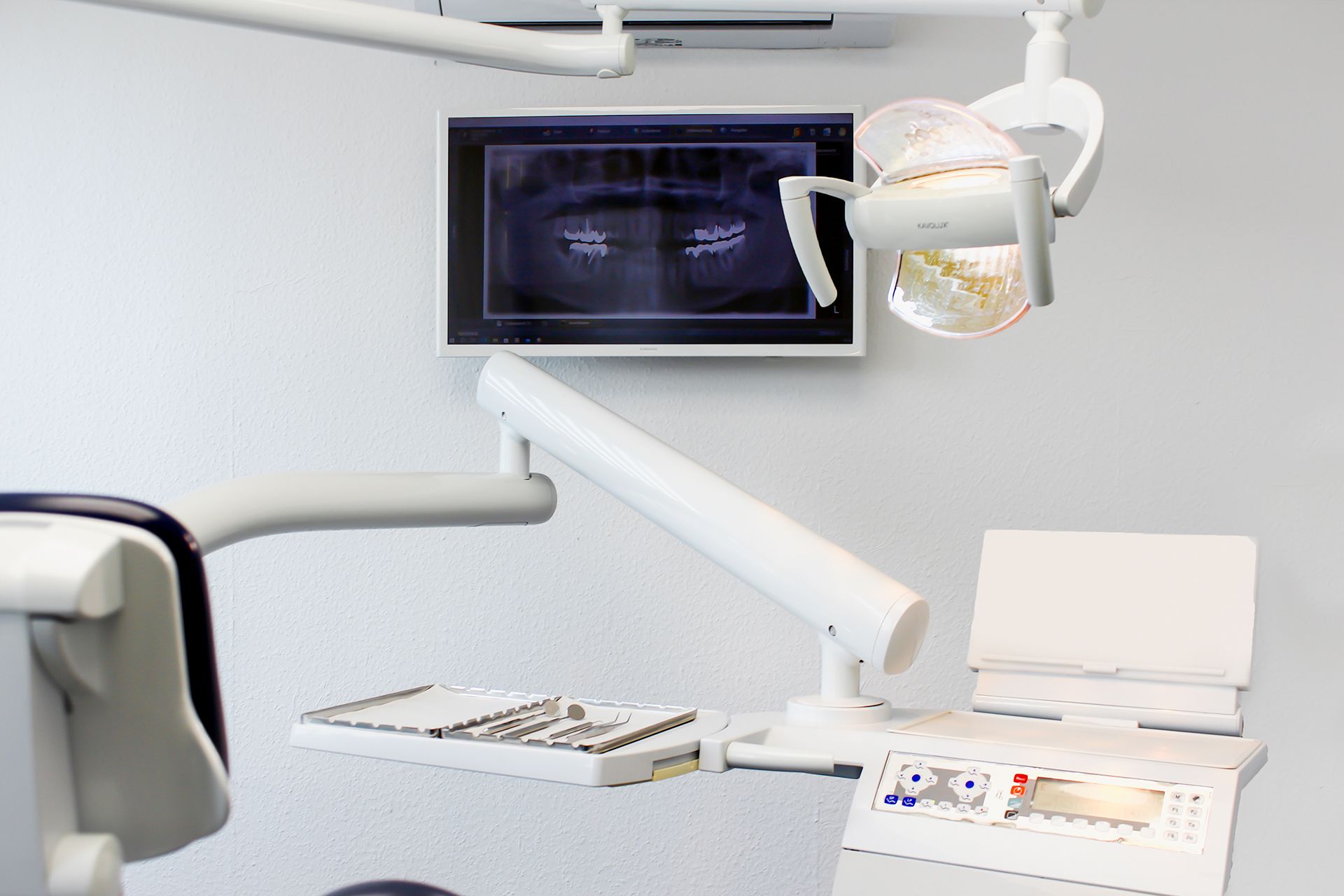 Behandlungszimmer mit Blick auf ein Display mit einer Röntgenaufnahme